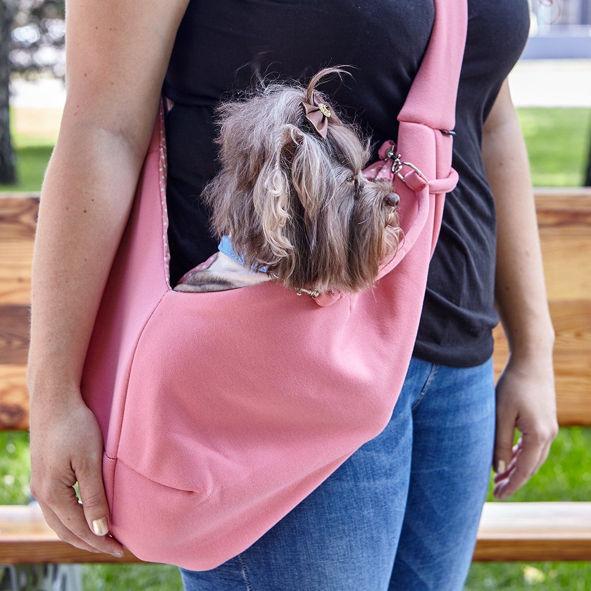 A girl wearing a Comfortable pet slings with her dog in it great for for carrying small dogs and cats – hands-free, adjustable, and stylish pet carriers