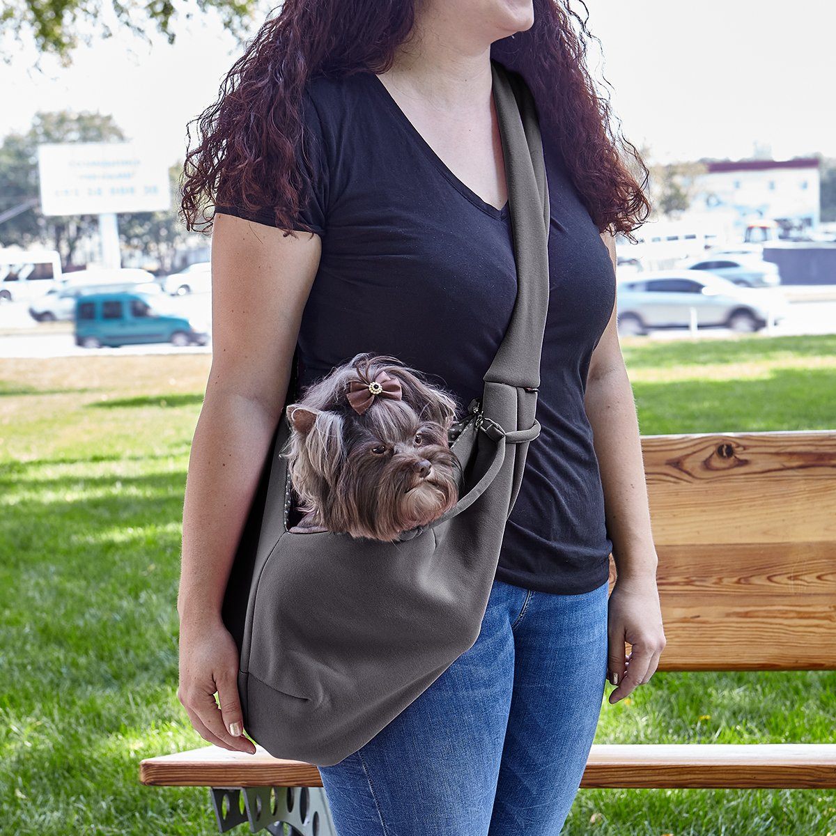 A girl wearing a Comfortable pet slings with her dog in it great for for carrying small dogs and cats – hands-free, adjustable, and stylish pet carriers