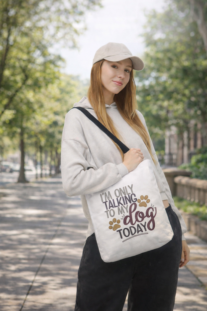 female dog lover carrying funny “I’m Only Talking to My Dog Today” canvas tote bag in urban setting