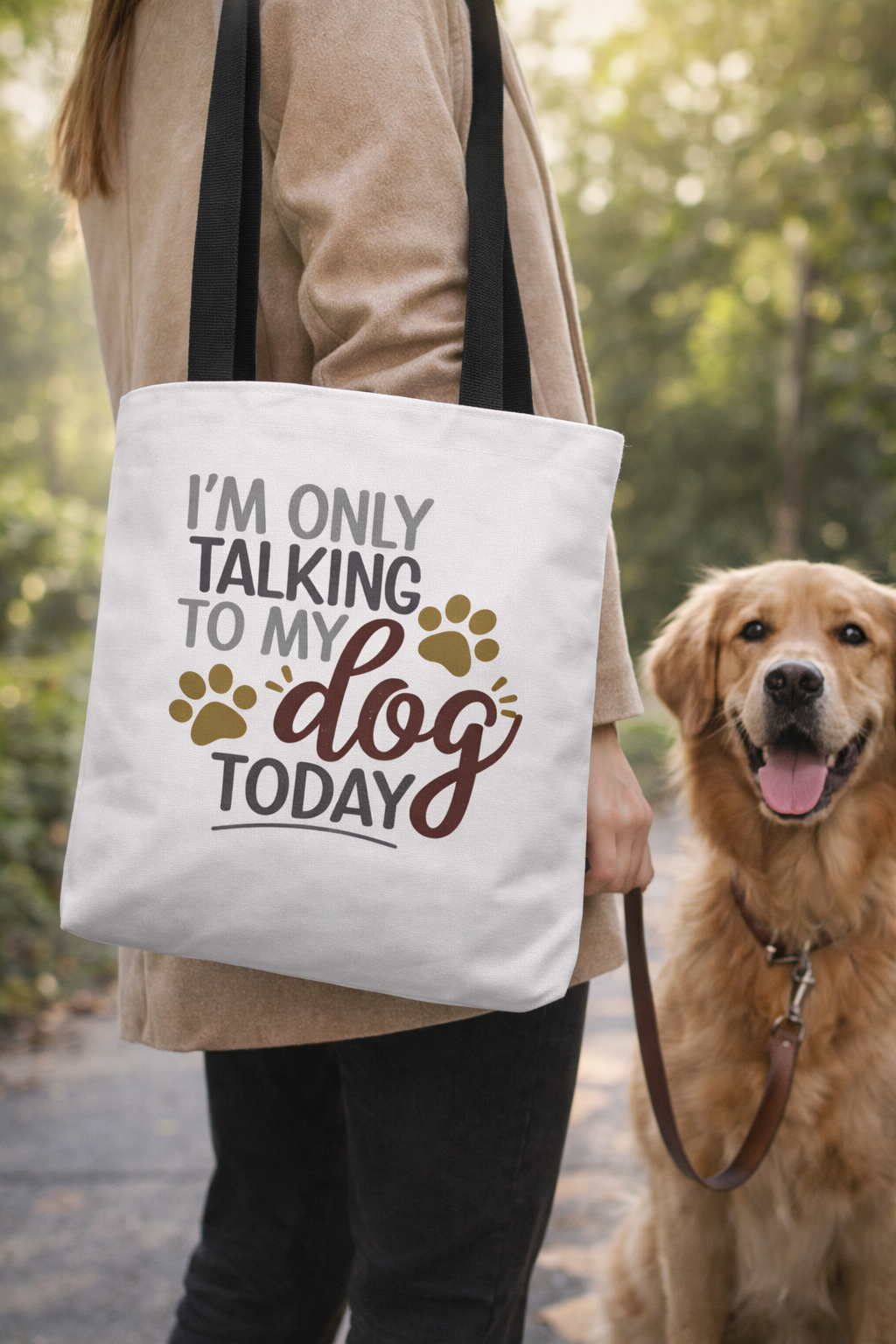 stylish woman wearing hat carrying dog lover tote bag with “I’m Only Talking to My Dog Today” quote in city while walking awe dog.